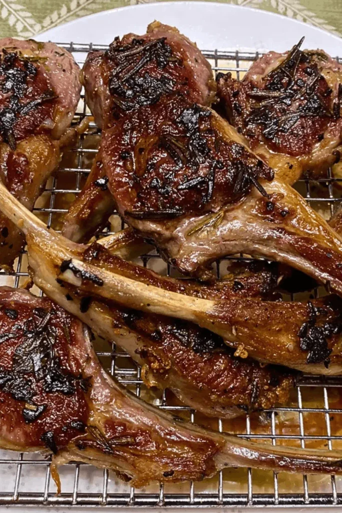 Seared garlic butter lamb chops with rosemary crust on a wire rack