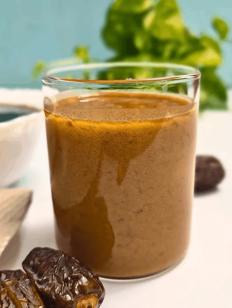 Close-up of creamy balsamic date vinaigrette in a glass with dates in foreground