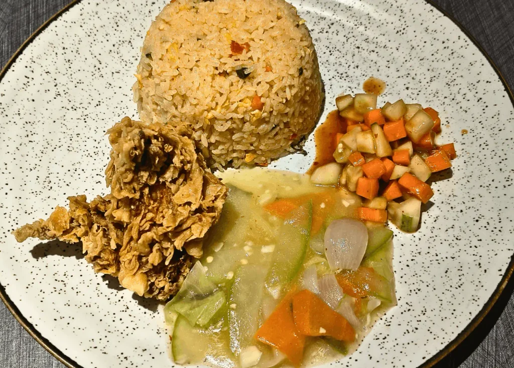 Top down view of crispy chicken fried rice with crispy chicken and pickled carrots