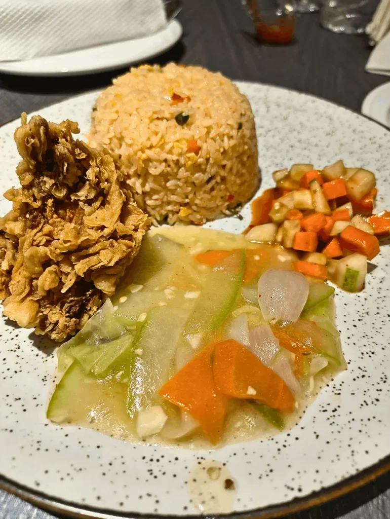 Plate of crispy chicken fried rice ready to eat with fried chicken on the side