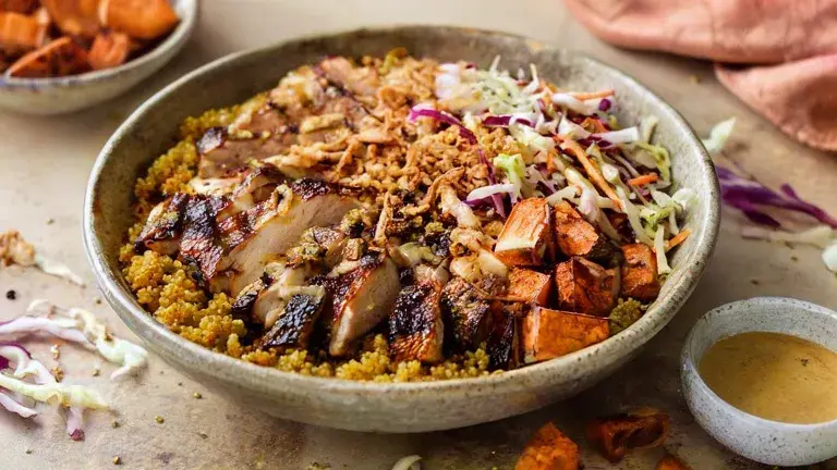 Sweetgreen hot honey chicken bowl with sliced chicken, quinoa, sweet potatoes, and slaw