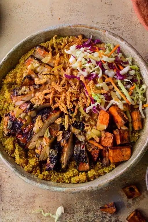 Overhead view of sweetgreen hot honey chicken bowl with chicken, slaw, and sweet potatoes