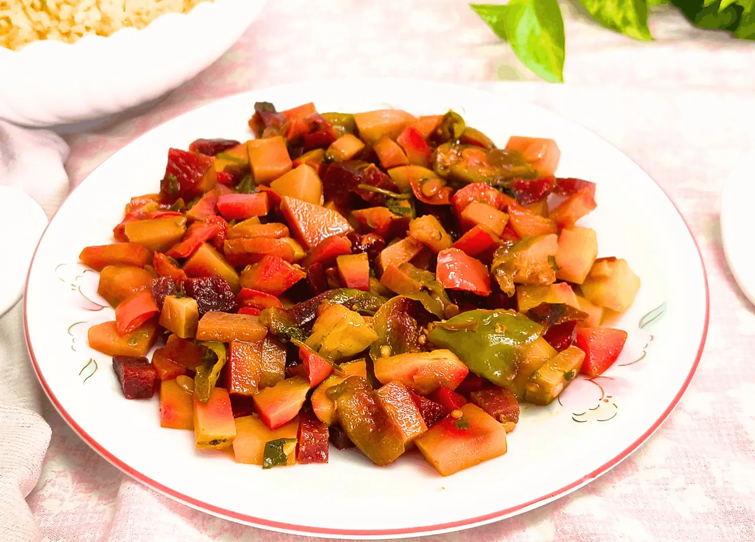 CAVA roasted vegetables copycat on a white plate with a bowl of rice in the background