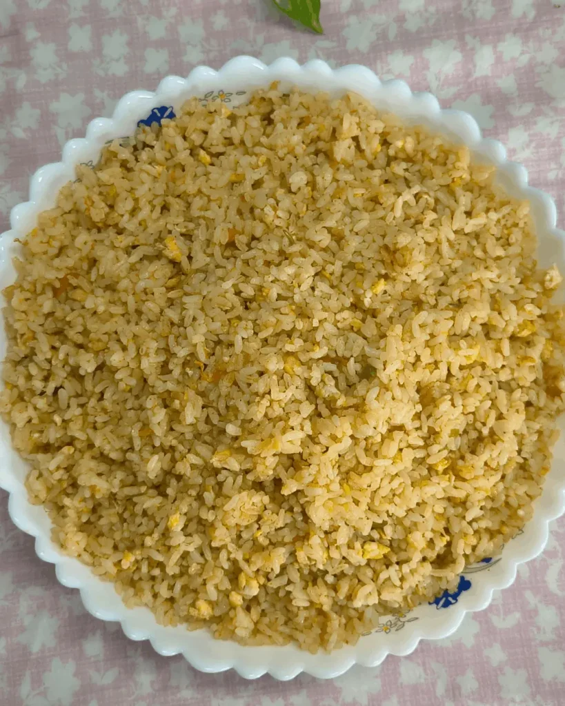 Overhead view of Cava brown rice variation with egg and green and red pepper in a floral rimmed bowl